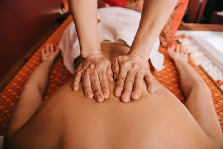 cropped view of masseur doing back massage to woman on massage mat